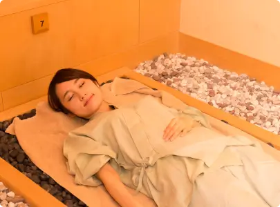 写真：岩盤浴をする女性